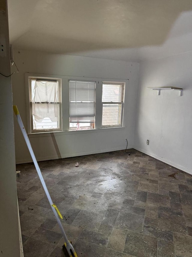 unfurnished room featuring baseboards