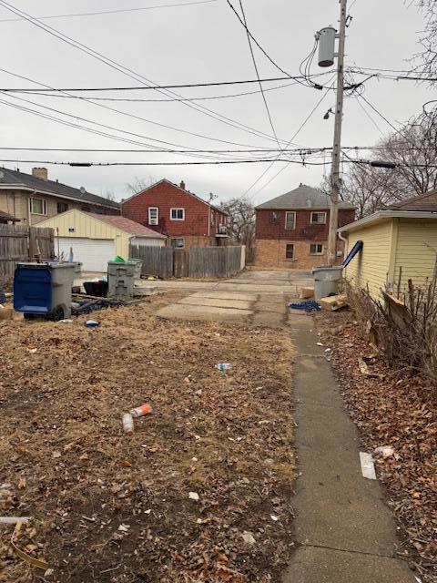 view of yard with fence and an outbuilding