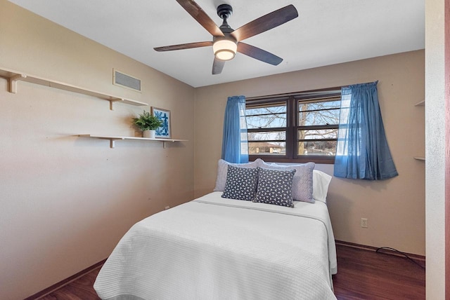 bedroom with wood finished floors, visible vents, and ceiling fan