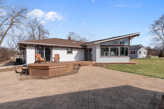 rear view of house featuring a wooden deck, central AC, a chimney, a yard, and a sunroom