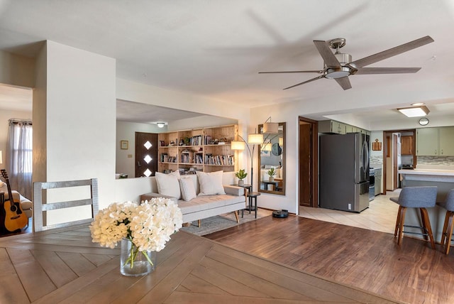 living room featuring light wood-style flooring and a ceiling fan