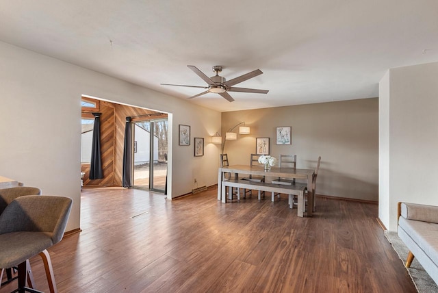 dining space featuring baseboards, wood finished floors, and a ceiling fan