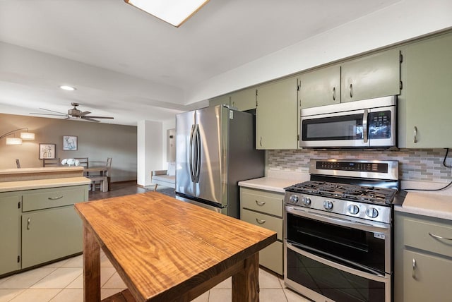 kitchen with light tile patterned floors, decorative backsplash, stainless steel appliances, and light countertops