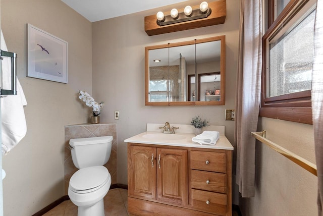 bathroom with tile patterned floors, baseboards, toilet, and vanity