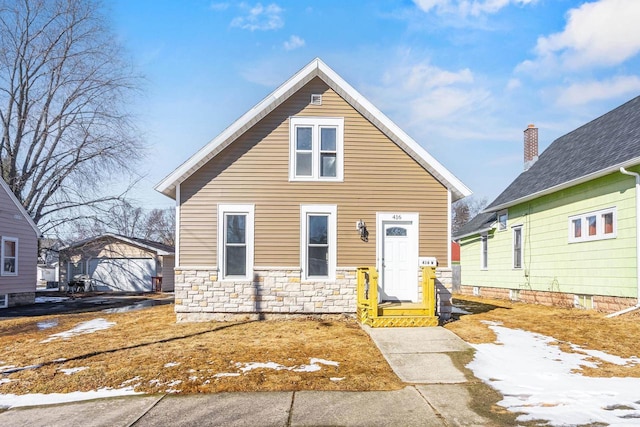 view of front of home featuring stone siding and an outdoor structure