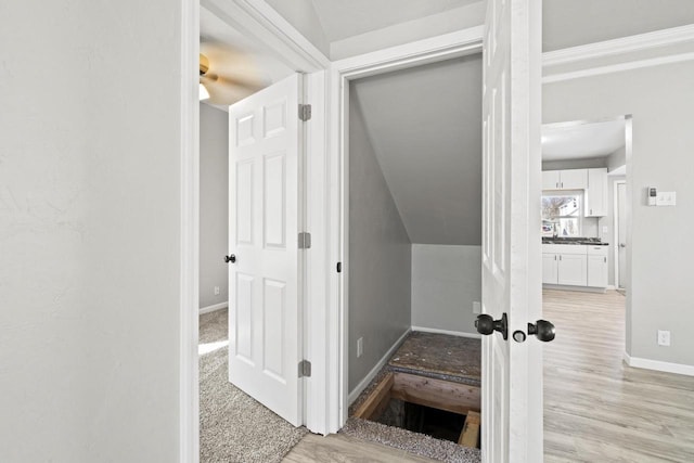 hall featuring light wood-style floors and baseboards