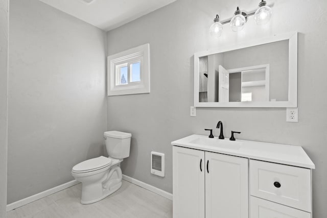 bathroom featuring toilet, baseboards, visible vents, and vanity