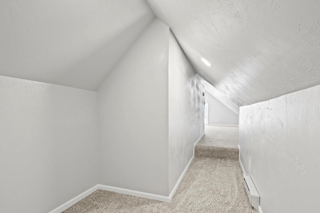 bonus room featuring vaulted ceiling, carpet floors, baseboard heating, and baseboards