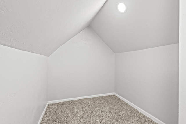 bonus room featuring carpet floors, vaulted ceiling, and baseboards