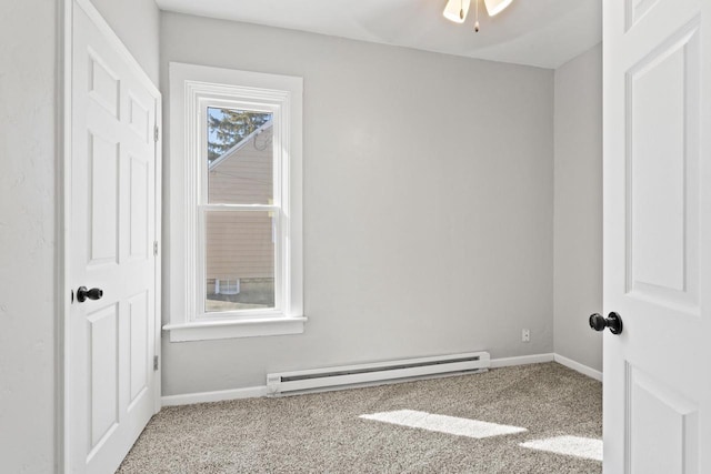 spare room with carpet floors, ceiling fan, baseboards, and baseboard heating