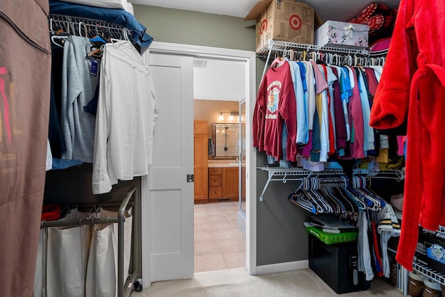 walk in closet with carpet and tile patterned floors