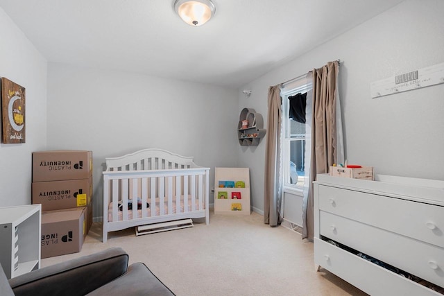 bedroom with light colored carpet, a crib, and baseboards