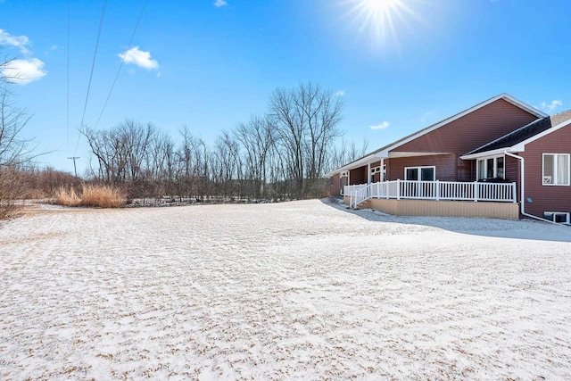 snowy yard featuring covered porch