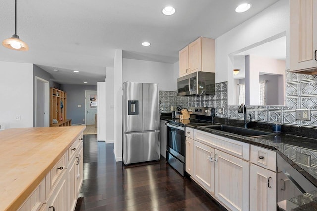 kitchen with stainless steel appliances, butcher block countertops, dark wood-type flooring, a sink, and decorative backsplash