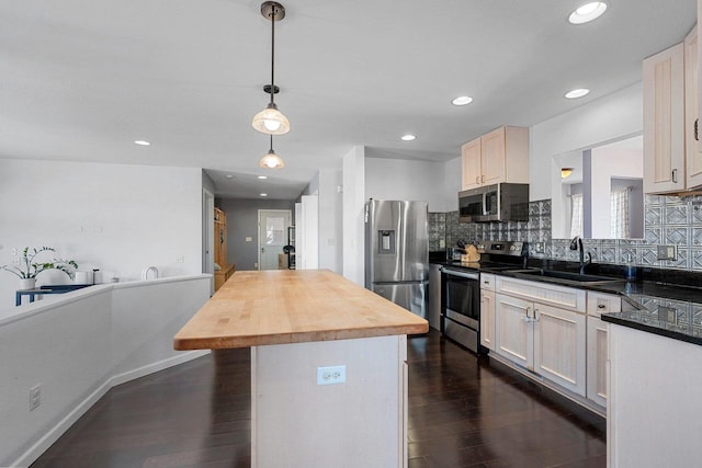 kitchen featuring dark wood-style flooring, a sink, wooden counters, appliances with stainless steel finishes, and backsplash