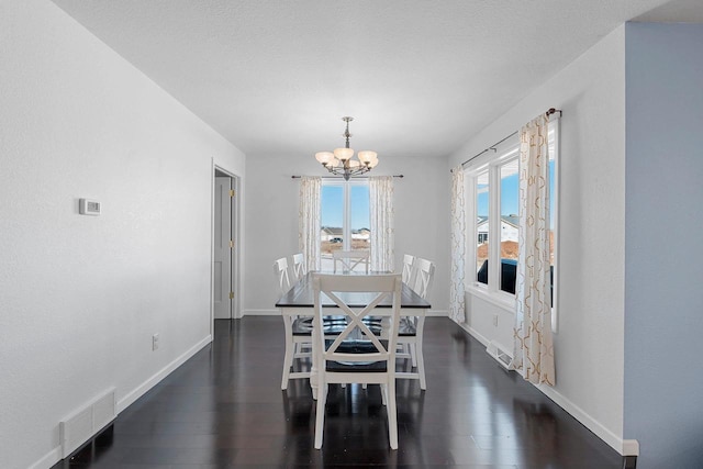 dining area with baseboards, wood finished floors, visible vents, and a notable chandelier