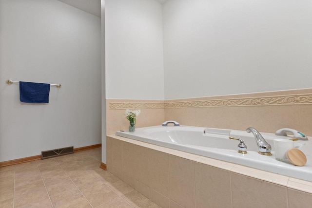 bathroom featuring tile patterned flooring, a garden tub, baseboards, and visible vents