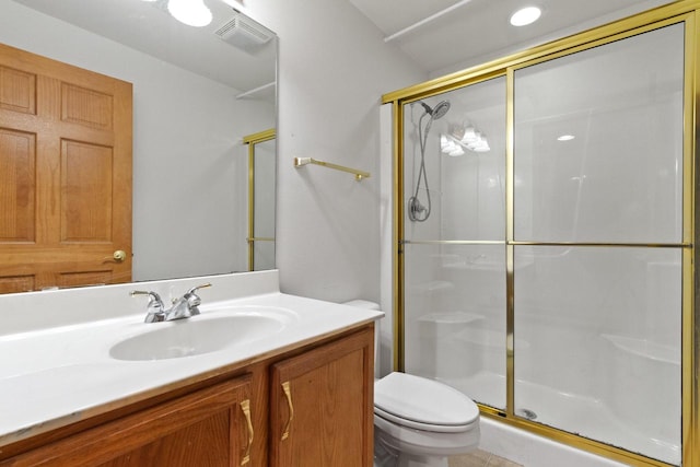 bathroom with vanity, a shower stall, toilet, and visible vents