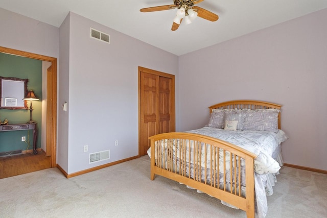 carpeted bedroom featuring a closet, visible vents, and baseboards