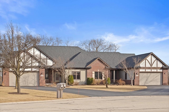 view of front of property with brick siding, driveway, a garage, and roof with shingles