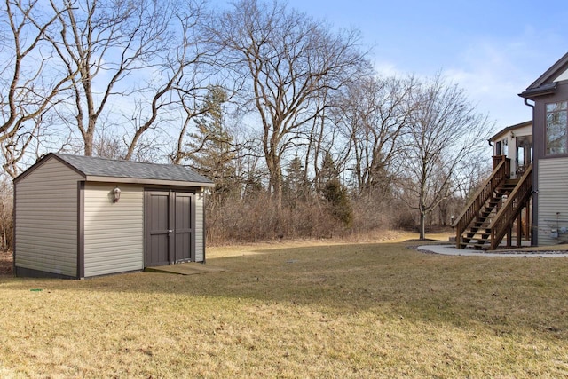 view of yard featuring stairs, a storage shed, and an outdoor structure