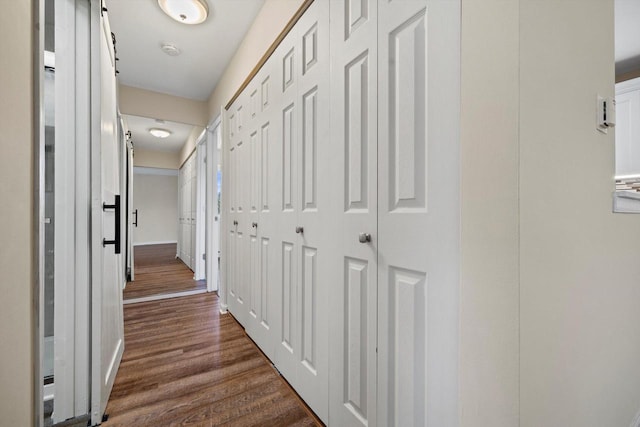 corridor featuring baseboards and dark wood-style flooring