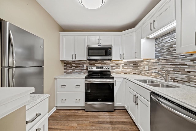 kitchen featuring appliances with stainless steel finishes, light countertops, a sink, and light wood-style flooring