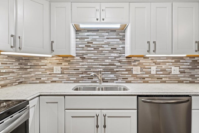 kitchen featuring a sink, white cabinets, light countertops, backsplash, and dishwasher