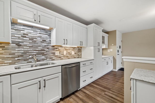 kitchen featuring dark wood-style flooring, decorative backsplash, stainless steel dishwasher, white cabinets, and a sink