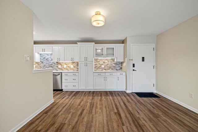 kitchen featuring dark wood-type flooring, white cabinetry, light countertops, dishwasher, and tasteful backsplash