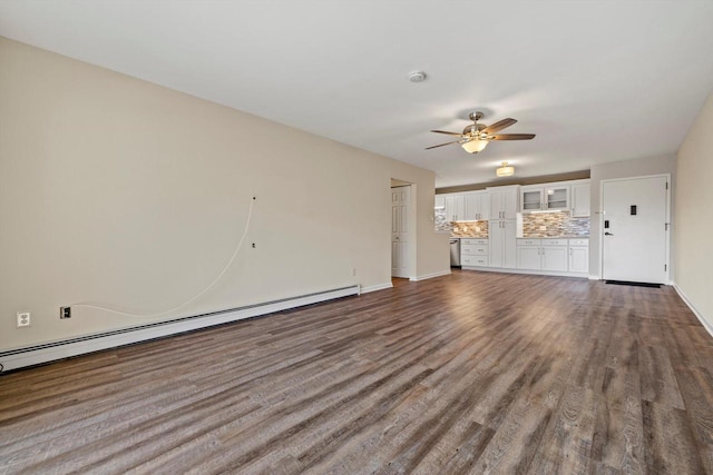 unfurnished living room featuring a baseboard heating unit, dark wood-type flooring, baseboards, and a ceiling fan