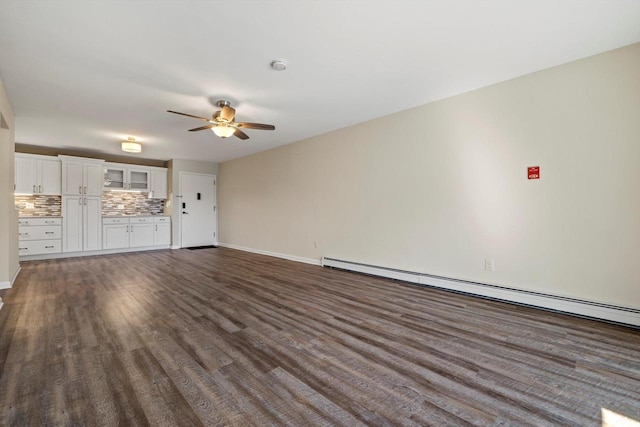 unfurnished living room with baseboards, a ceiling fan, baseboard heating, and dark wood-type flooring