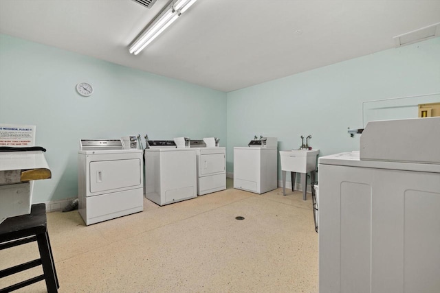 common laundry area featuring washer and dryer and a sink