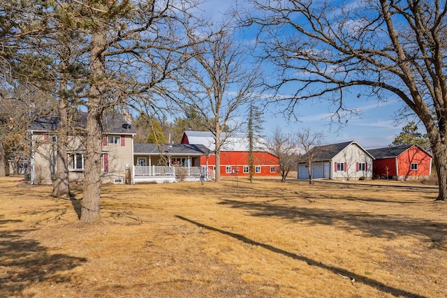 view of yard featuring a garage and covered porch