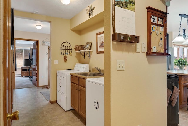 laundry area with a wealth of natural light, cabinet space, baseboards, and a sink