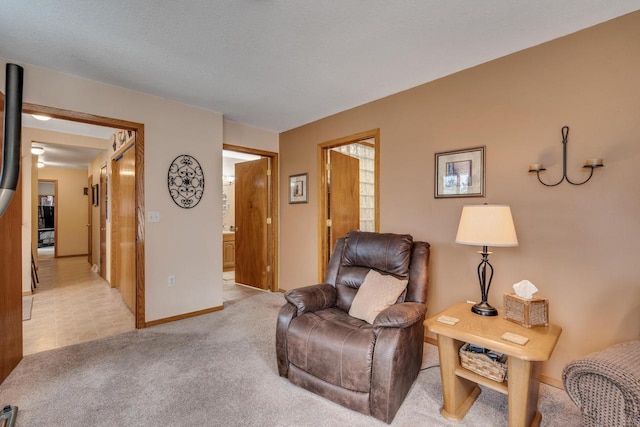 living area featuring light carpet and baseboards