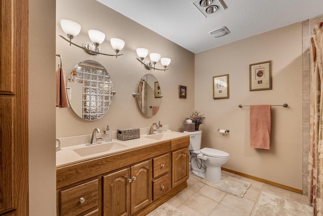 bathroom featuring double vanity, a sink, toilet, and baseboards