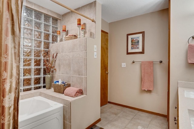 full bathroom featuring a washtub, a shower with curtain, a textured ceiling, and baseboards