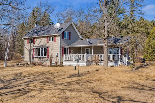 view of front facade with a porch, a chimney, and a front yard