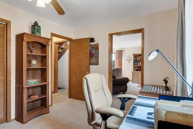 office area with a ceiling fan and light colored carpet