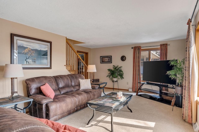 carpeted living room with stairs and baseboards