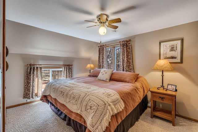 bedroom featuring baseboards, vaulted ceiling, a ceiling fan, and light colored carpet