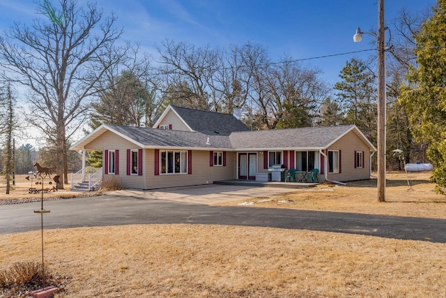 view of front of home featuring a shingled roof and driveway