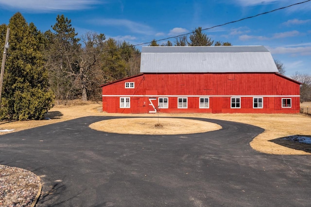 exterior space featuring aphalt driveway, an outbuilding, and a barn