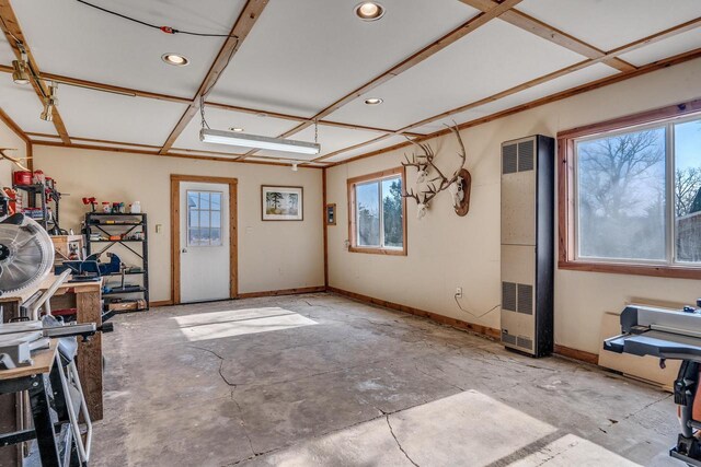 interior space with baseboards, unfinished concrete flooring, and a wealth of natural light