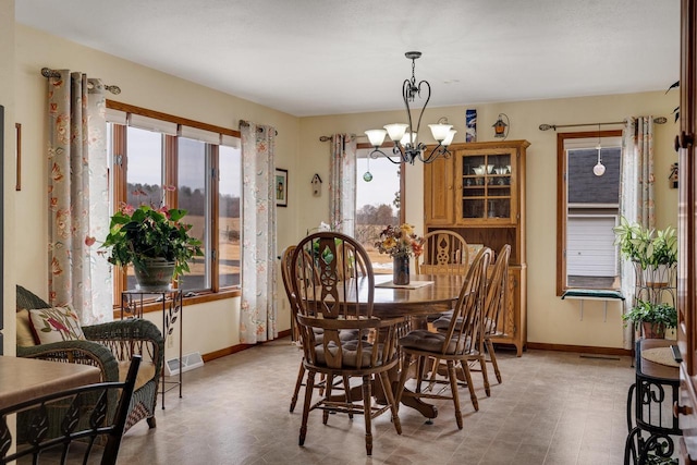 dining space featuring an inviting chandelier and baseboards