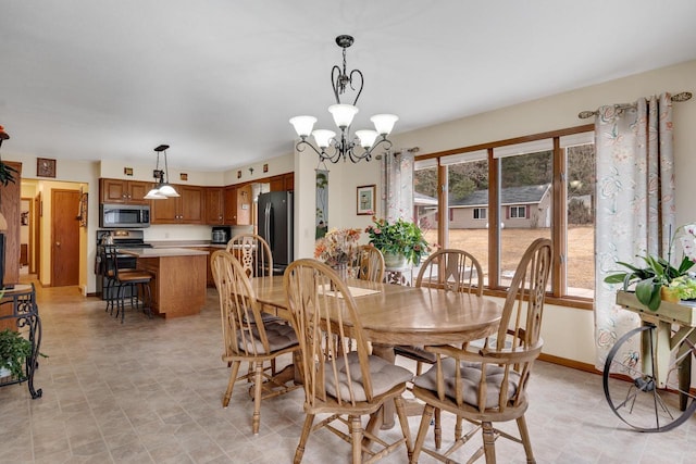 dining space with baseboards and a notable chandelier