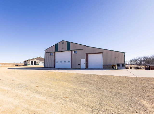 view of outbuilding featuring concrete driveway and an outdoor structure