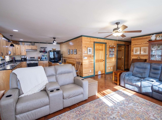 living area with wood walls and a ceiling fan