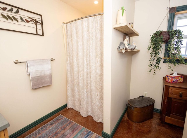 bathroom with a shower with curtain, finished concrete floors, and baseboards